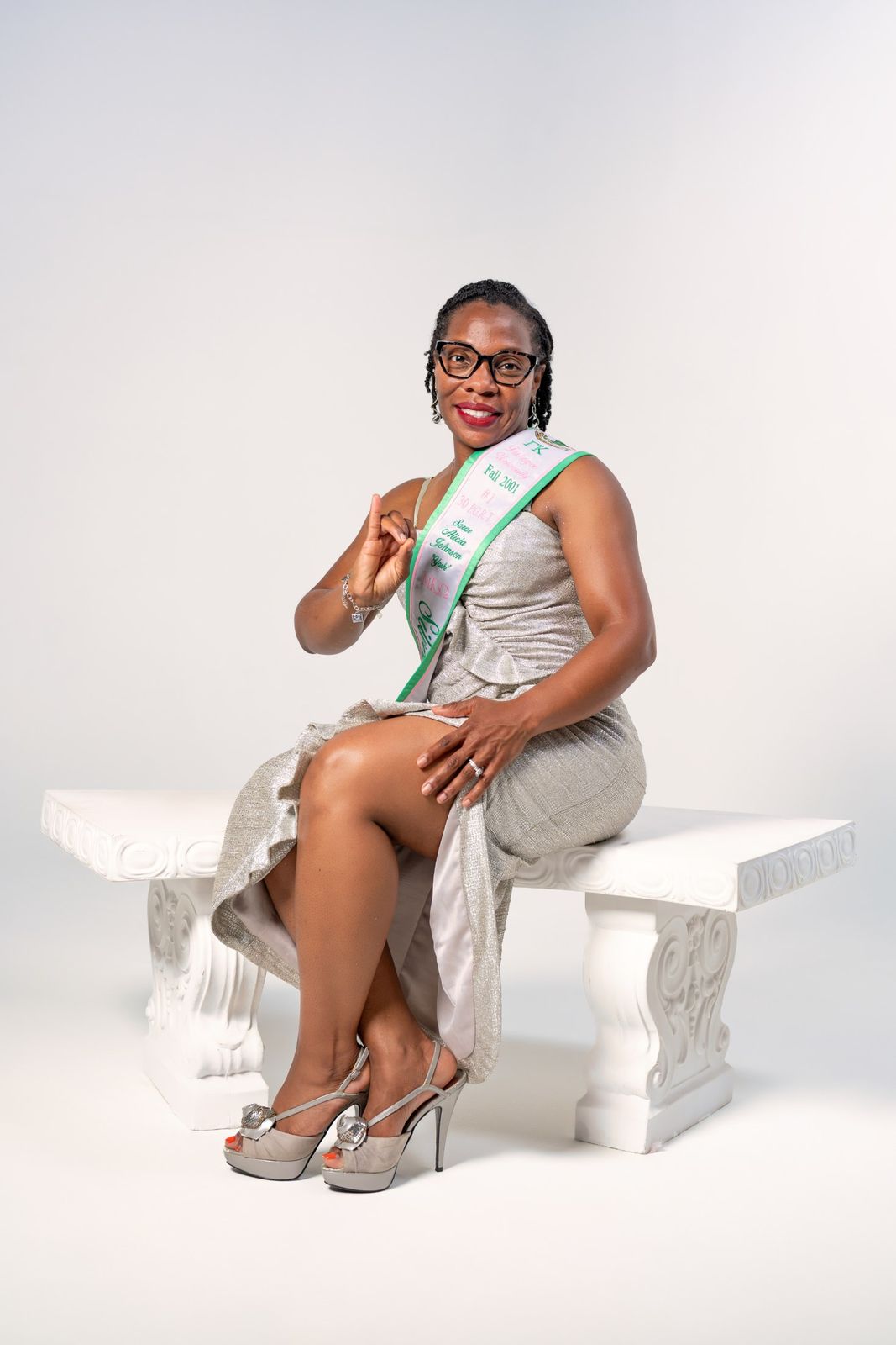 Seated portrait on white bench with sash