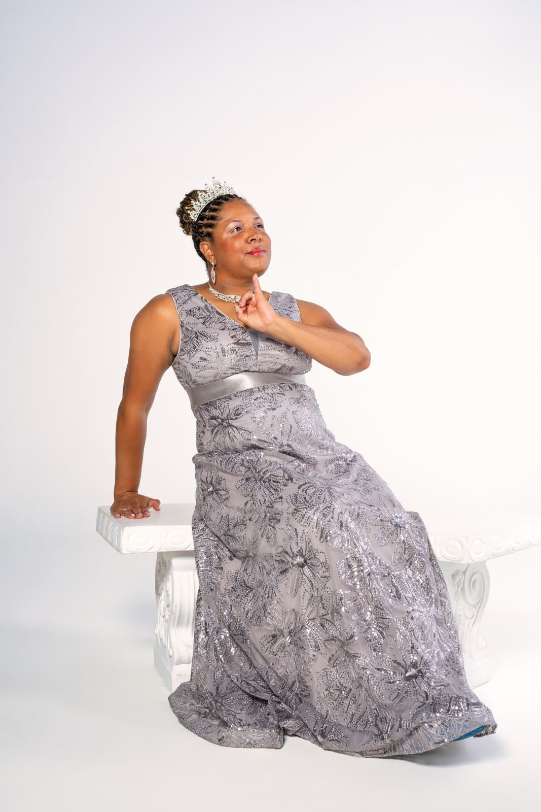 Seated portrait on white bench, tiara and gown